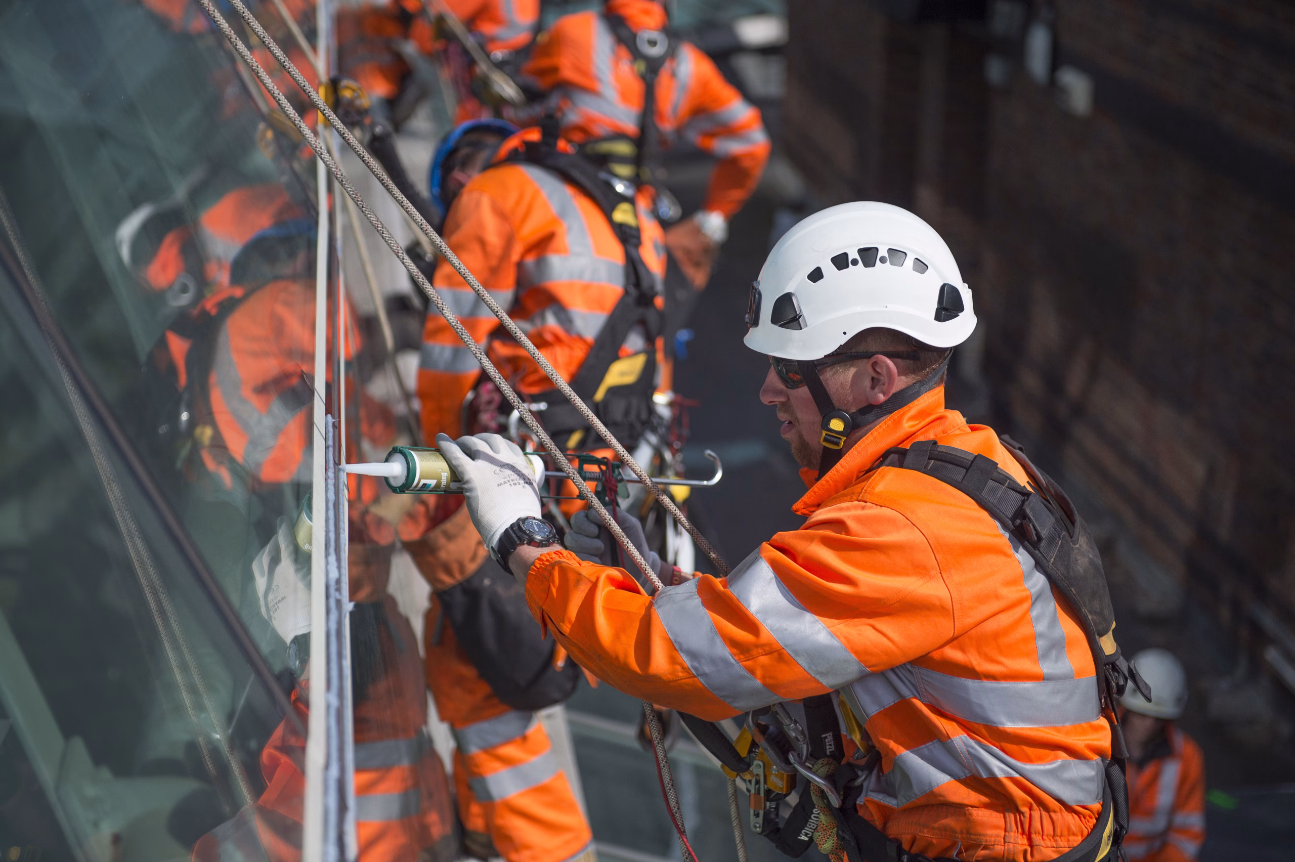Team member secured with ropes using a caulking gun