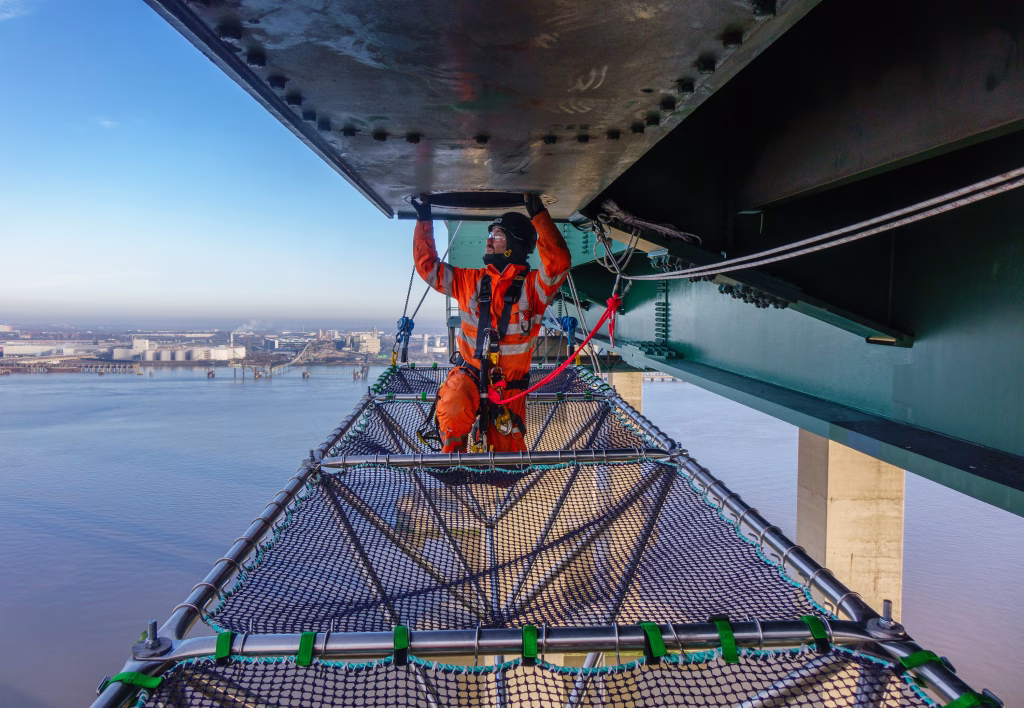 Worker under a bridge using a platform
