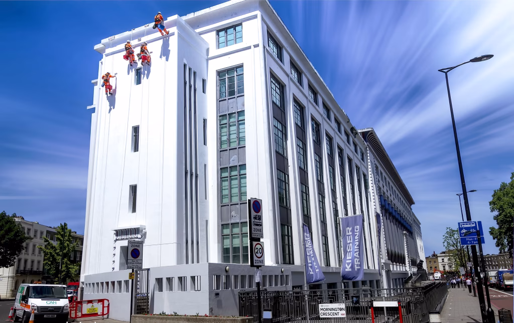 Workers on the side of a building secured by ropes