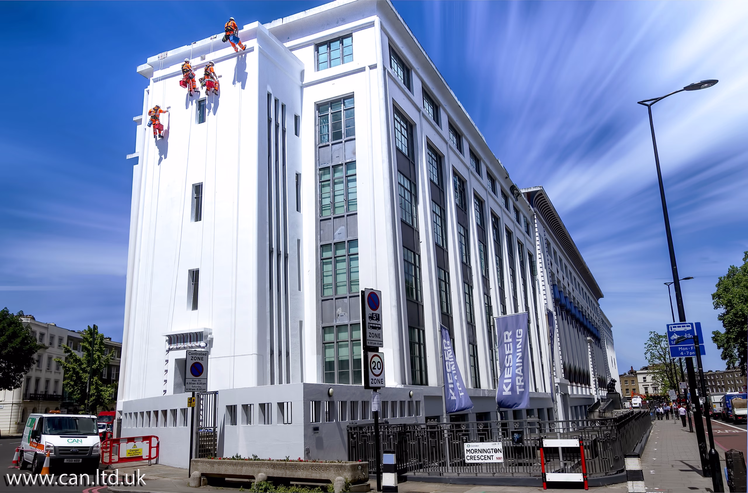 Workers on the side of a building secured by ropes