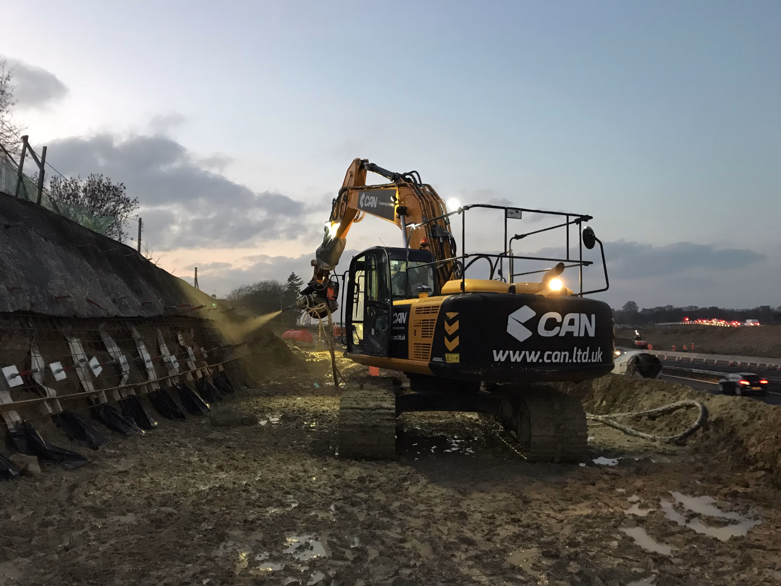 Heavy machinery working on a retaining wall.